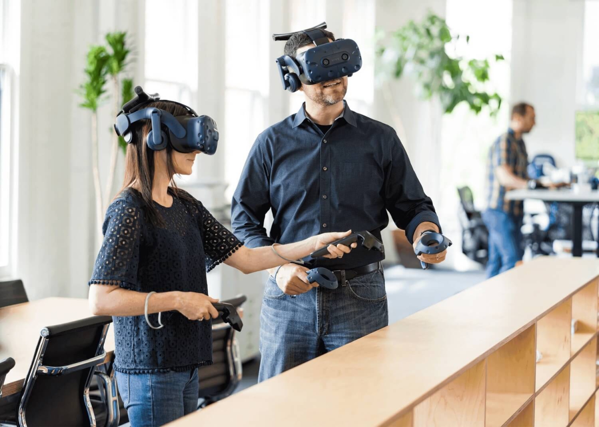 homme et femme côte à côte portant casques et contrôleurs VR