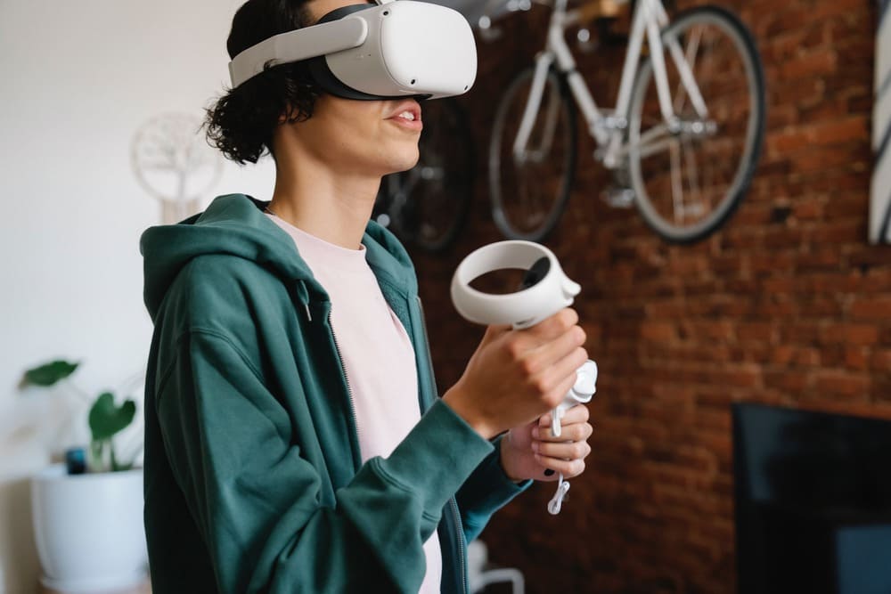 Homme accroupis dans salon portant casque VR et contrôleurs