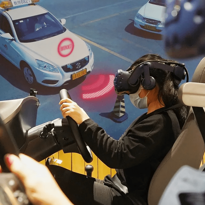 Asseyez-vous sur une chaise, mettez un casque VR et apprenez à conduire